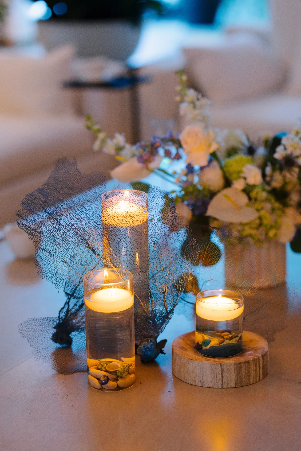 Floating candles, a sea fan and white flowers on a low table